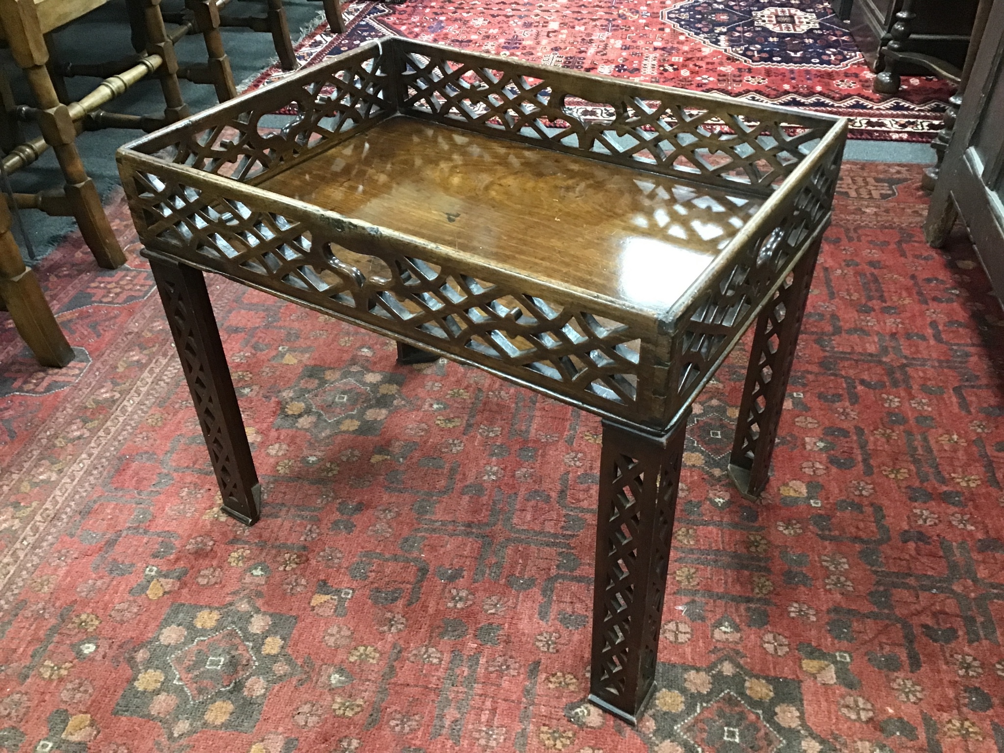 A George III pierced mahogany rectangular tray now as an occasional table on associated legs, width 59cms, depth 43cms, height 50cms.
